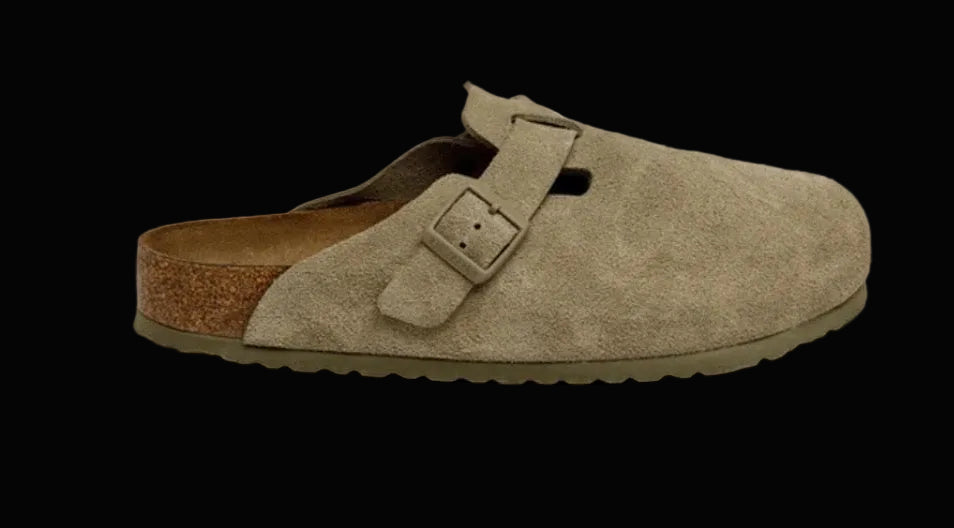 Beige suede clog shoe with a brown sole on a white background