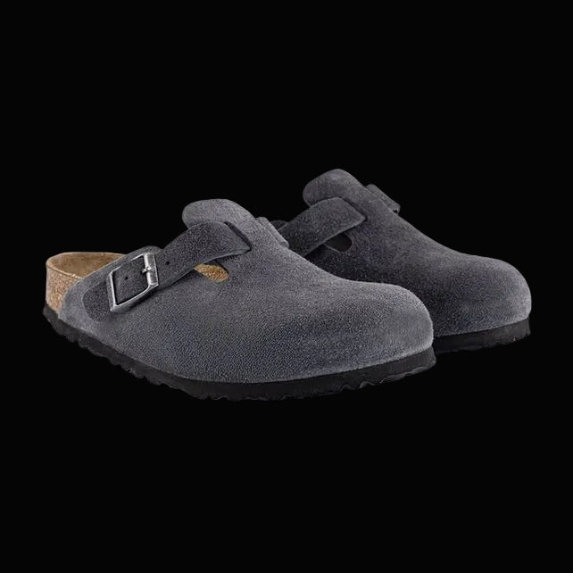 Pair of gray suede clogs with a buckle on a light gray background